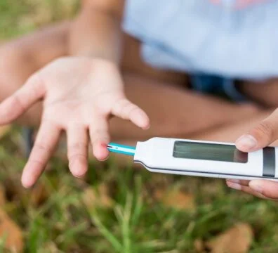Girl testing diabetes on glucose meter