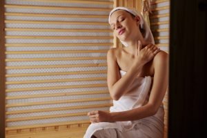 Woman enjoying self massage in sauna